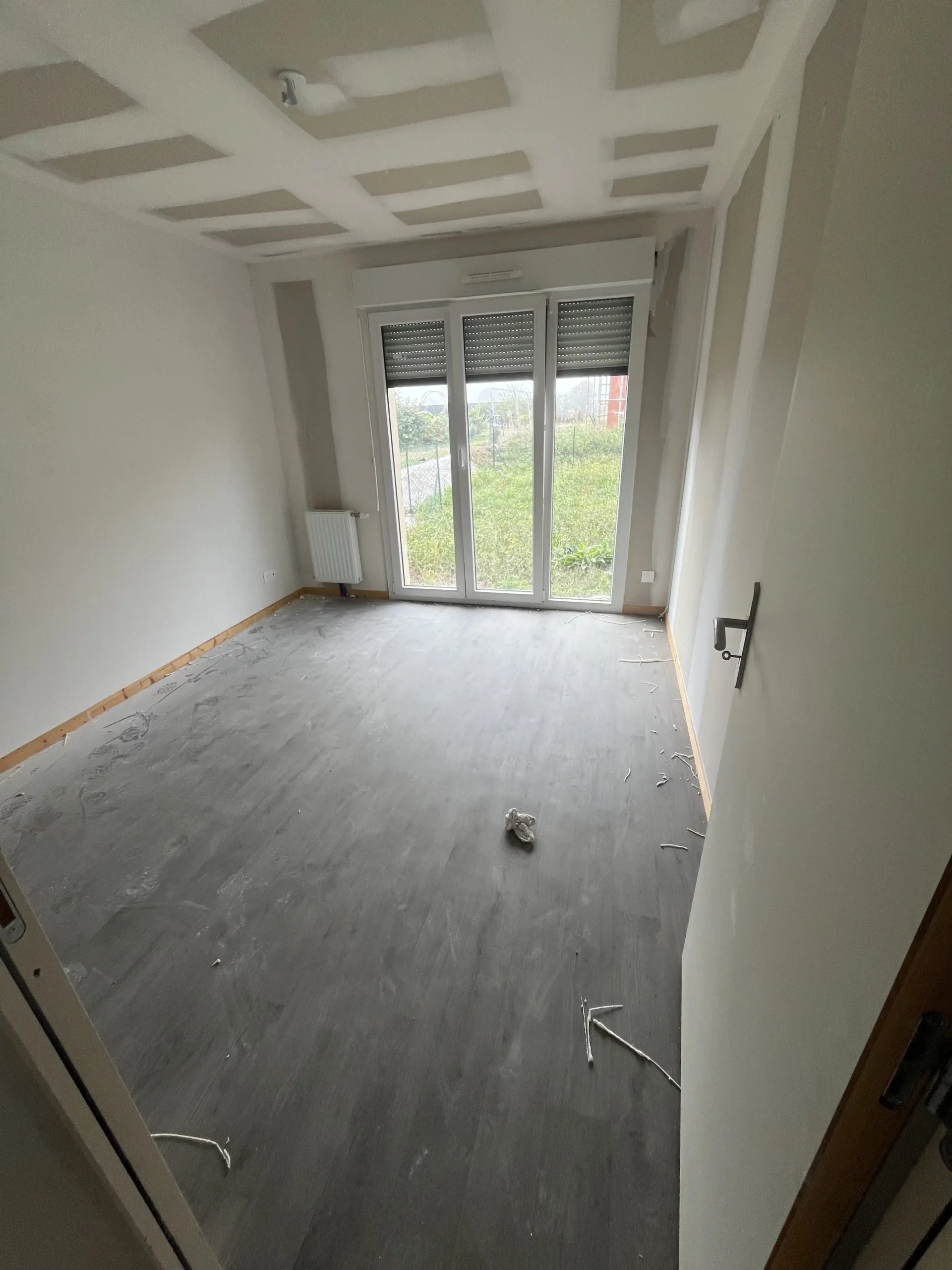 Chambre avant nettoyage de fin de chantier, sol poussiéreux et fils au sol