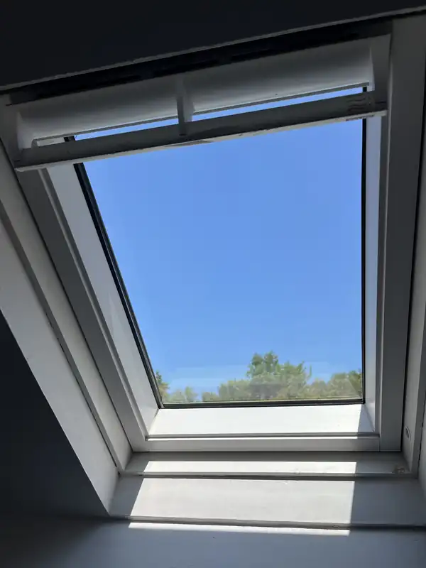 Même fenêtre de toit vue de l'intérieur après nettoyage, ciel parfaitement dégagé