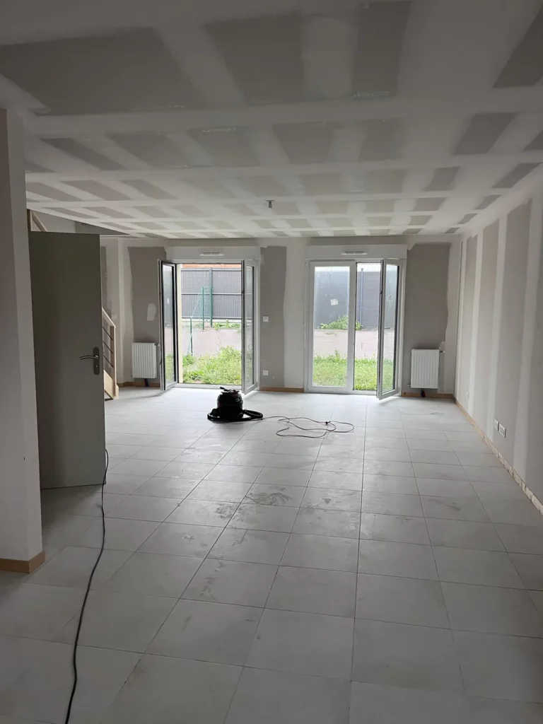 Séjour d'une maison neuve avant nettoyage de fin de chantier, carrelage poussiéreux